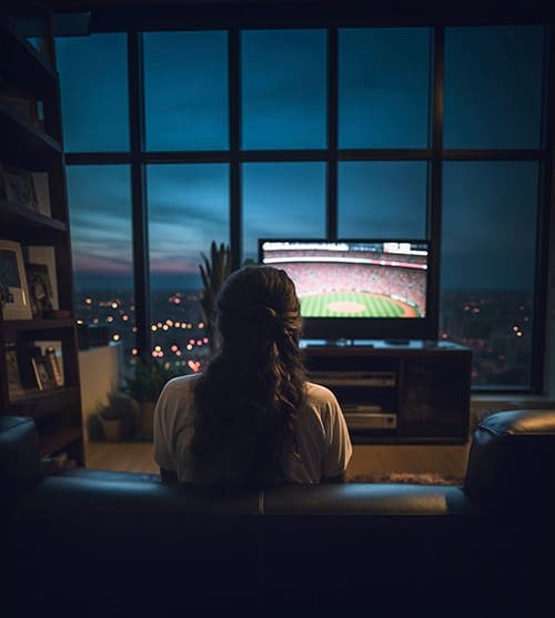 Mulher assistindo TV após a contratação de nosso IPTV